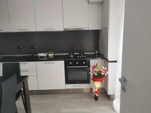 a kitchen with white cabinets and a vase of flowers at B85 Studio in Craiova