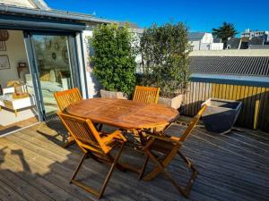 a wooden table and chairs on a deck at Cosy's Terrasse in Larmor-Plage