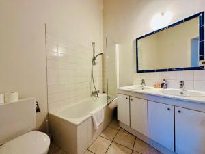 a bathroom with a tub and a sink and a toilet at Manneken View in Brussels