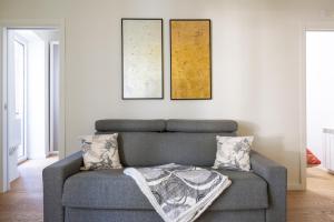 a gray couch in a living room with two pillows at Sendy Home Roccaraso 3 in Roccaraso