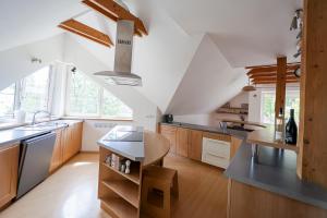 a kitchen with white walls and wooden cabinets at Apartman Anton Kvačany in Kvačany