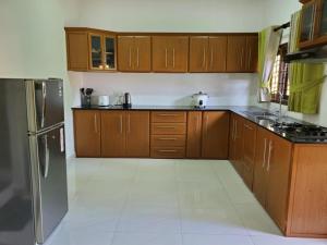 a kitchen with wooden cabinets and a stainless steel refrigerator at Bopitiya Residence 20 Mins from Airport in Bopitiya +11 photos