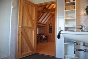 a bathroom with a wooden door and a sink at Erfgoed & Logies Den Heijkant in Moergestel +78 photos