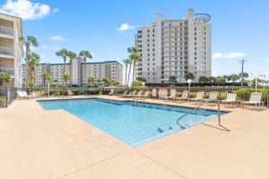 Una piscina con sillas y un edificio. en Grand Caribbean West 215, en Perdido Key