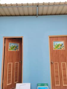 Dos puertas de madera en una habitación con una pared. en Riverland Camp, en Phumĭ Chheutéal (2)