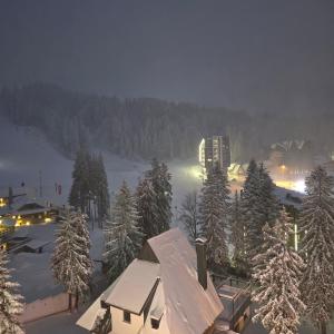 a view of a ski lodge in the snow at night at Sun&Snow Jahorina in Jahorina