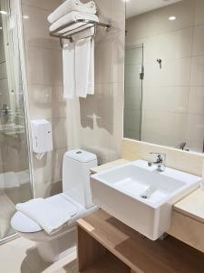 a bathroom with a white toilet and a sink at Hotel de Alto Padrão Com Vista Livre Incrível!! Cama King Size Cond Hotel Alvorada in Brasilia