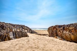 a sandy beach with rocks and the ocean at Neptunes Grand View in Lincoln City