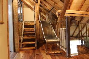 a leather chair in a room with stairs at fantastische vakwerk boerderij nabij Maastricht in Banholt