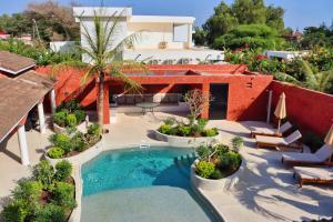 a patio with a swimming pool and a house at Keur Noel in Ngaparou