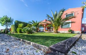 a house with palm trees in front of it at Casa La Perla in Golf of Peralada in Peralada