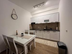 a kitchen with a table and a clock on the wall at Ruža vetrova Zlatar - A2 in Nova Varoš