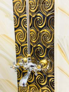 a chandelier hanging from a wall with gold and black swirls at The Lahore Guest House in Lahore