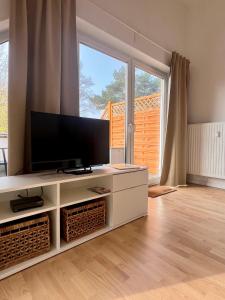 soggiorno con TV a schermo piatto e armadio bianco di Strandglück a Graal-Müritz