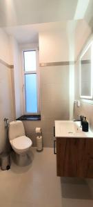 Un baño con inodoro, lavabo y ventana. en Stacja Jeżyce, en Poznan