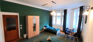 Una sala de estar con un sofá azul y una pared verde. en Stacja Jeżyce, en Poznan