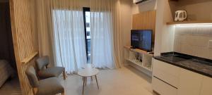 een woonkamer met een televisie en een kamer met een raam bij Complejo Cantal Porto in Salta