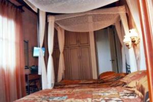 Manganos Apartments في كامبوس: غرفة نوم بسرير مع مظلة