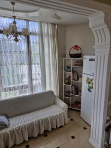 a living room with a couch in front of a window at Jumber&Lela in Batumi