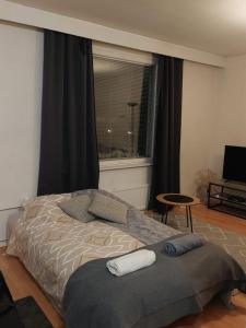 a bedroom with a bed and a window and a chair at Railway&bus station studio in Oulu