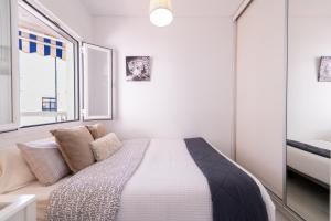 a white bedroom with a bed and a window at 1st line Paseo marítimo en el puerto deportivo de Marbella in Marbella +17 photos