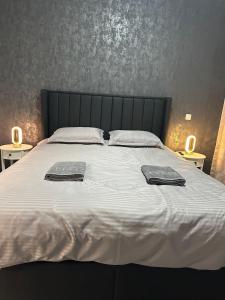 a large bed with two towels on top of it at Alex Mnl Lux Apartment free parking D12 in Bucharest