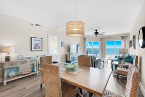 a dining room and living room with a table and chairs at Emerald Isle unit 406 in Pensacola Beach