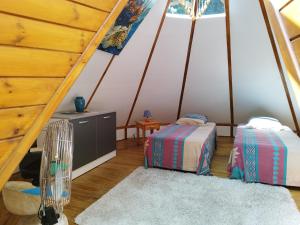 a room with two beds in a attic at Gite du Manial Tipi bois Danse du Soleil in Pointe-Noire