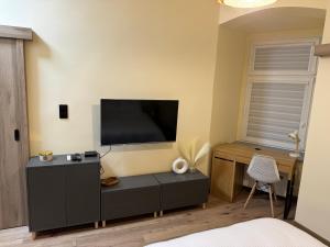 a bedroom with a flat screen tv on the wall at Bastet Apartamenty in Świdnica