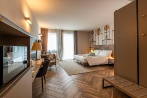 a hotel room with a bed and a television at Bed & Breakfast LA HOME and Apartments in Moniga