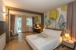 a bedroom with a large bed with a painting on the wall at Bed & Breakfast LA HOME and Apartments in Moniga +111 photos
