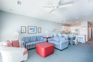 ペンサコーラ・ビーチにあるWhite Sands 449のソファとテーブルとキッチンのあるリビングルーム