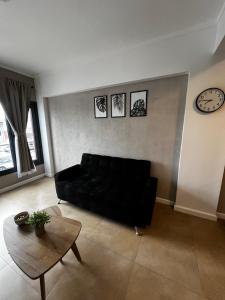 a living room with a black couch and a table at Alquiler en pleno centro in Río Grande