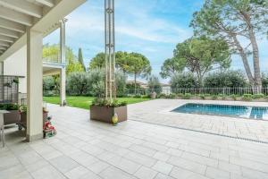 a patio with a swimming pool in a yard at Bed & Breakfast LA HOME and Apartments in Moniga