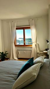 1 dormitorio con 1 cama con cortinas blancas y ventana en La Coppetta di CrisandSimo, en Perugia 17 fotos más