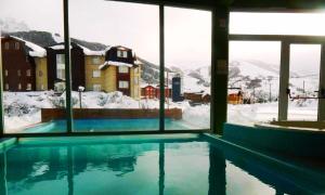 a swimming pool with a view of a snow covered mountain at Latitud Catedral Apartamento in San Carlos de Bariloche