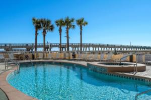 a swimming pool with palm trees and a pier at Summerwind Center 1304 in Navarre