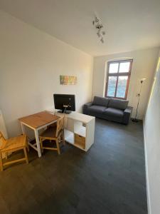 a living room with a couch and a desk with a computer at Schlossblick in Oranienbaum