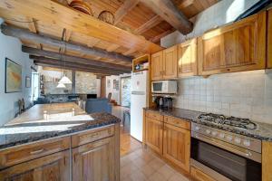 eine Küche mit Holzschränken und einem Herd mit Backofen in der Unterkunft Casa Parrot - Jardín privado y balcón con vistas by Eth Flòc in Gessa