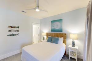 a white bedroom with a bed and a lamp at Barefoot Cottages #B32 in Highland View +29 photos