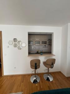 a kitchen with two bar stools and a counter at Verde apartments in Sarajevo +17 photos