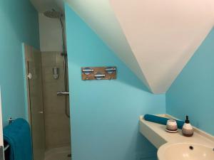 bagno blu con doccia e lavandino di Appartement, 2 chambres, Terrasse vue mer, très calme, Piscine premium, accès direct aux plages, restaurants, Village Vacances a Sainte-Luce
