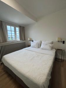 a white bed in a bedroom with a window at Hotel La Chaumiere in Asse +52 photos