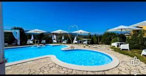 a large swimming pool with chairs and umbrellas at I Giardini Di Eidos in Sant'Agata de' Goti