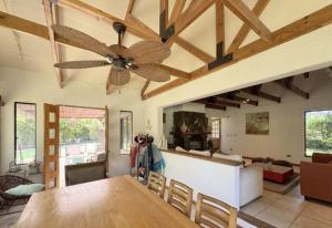 un soggiorno con ventilatore a soffitto e tavolo di Casa en lago rapel, quincho, piscina, acceso al lago Familiar a Lago Rapel