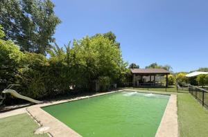 una piscina con acqua verde in un cortile di Casa en lago rapel, quincho, piscina, acceso al lago Familiar a Lago Rapel