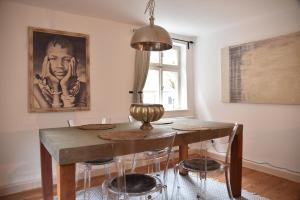 a dining room table with chairs and a painting on the wall at Das kleine Gästehaus in Dinkelsbühl