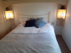 a bedroom with a white bed with two lights at Retro Caravan in Rye