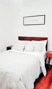 a bedroom with a white bed with a wooden headboard at Less than 10 mins from Downtown, early checkin-subject to availability, pool table in Atlanta