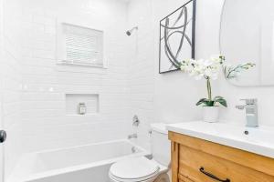 a white bathroom with a toilet and a tub and a sink at Less than 10 mins from Downtown, early checkin-subject to availability, pool table in Atlanta